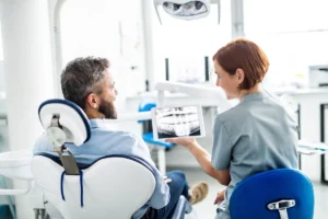 Rear view of man and dentist in dental surgery, annual check-up.