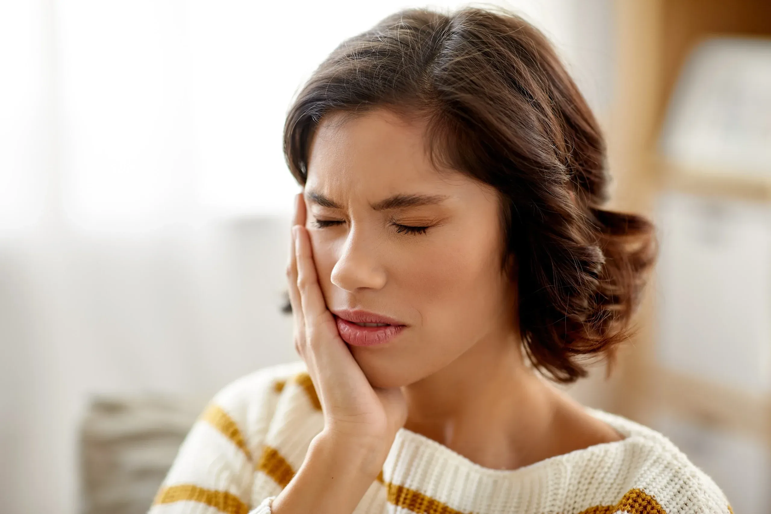 healthcare, dental health and problem concept - unhappy woman suffering from toothache at home