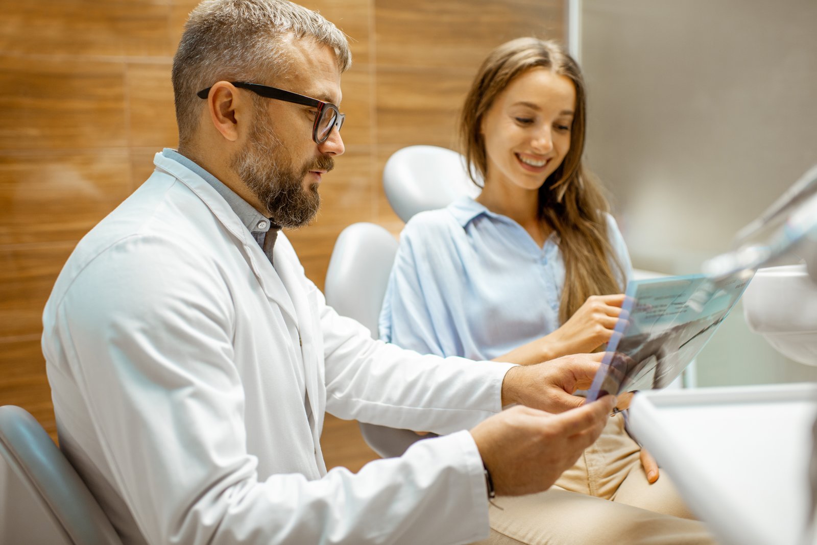Dental patient discussing financing options with a smiling receptionist at checkout