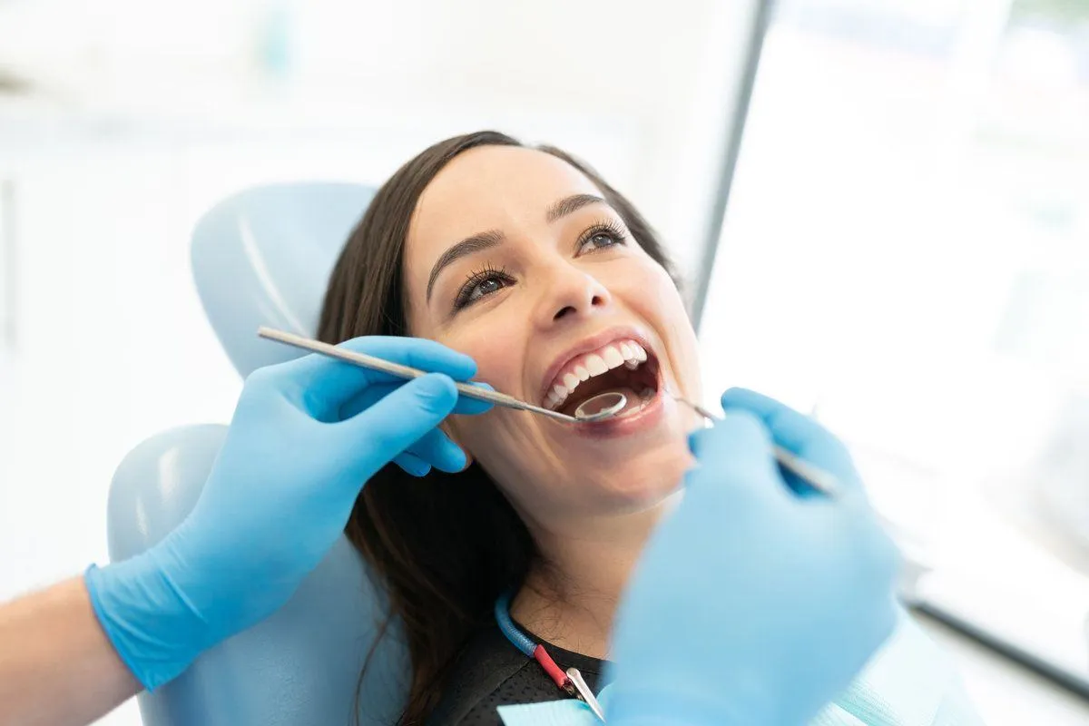 Dentist Checking Teeth Of Mid Adult Woman